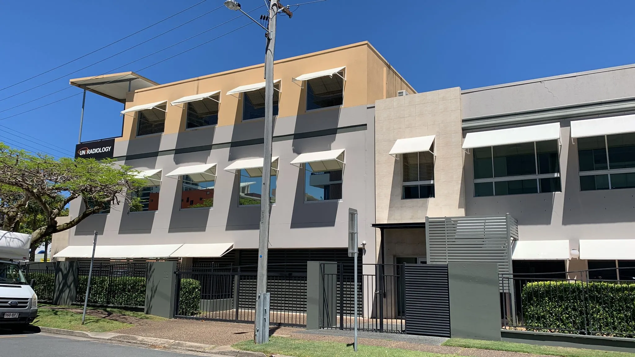 Three-storey UniRadiology medical imaging building with window awnings