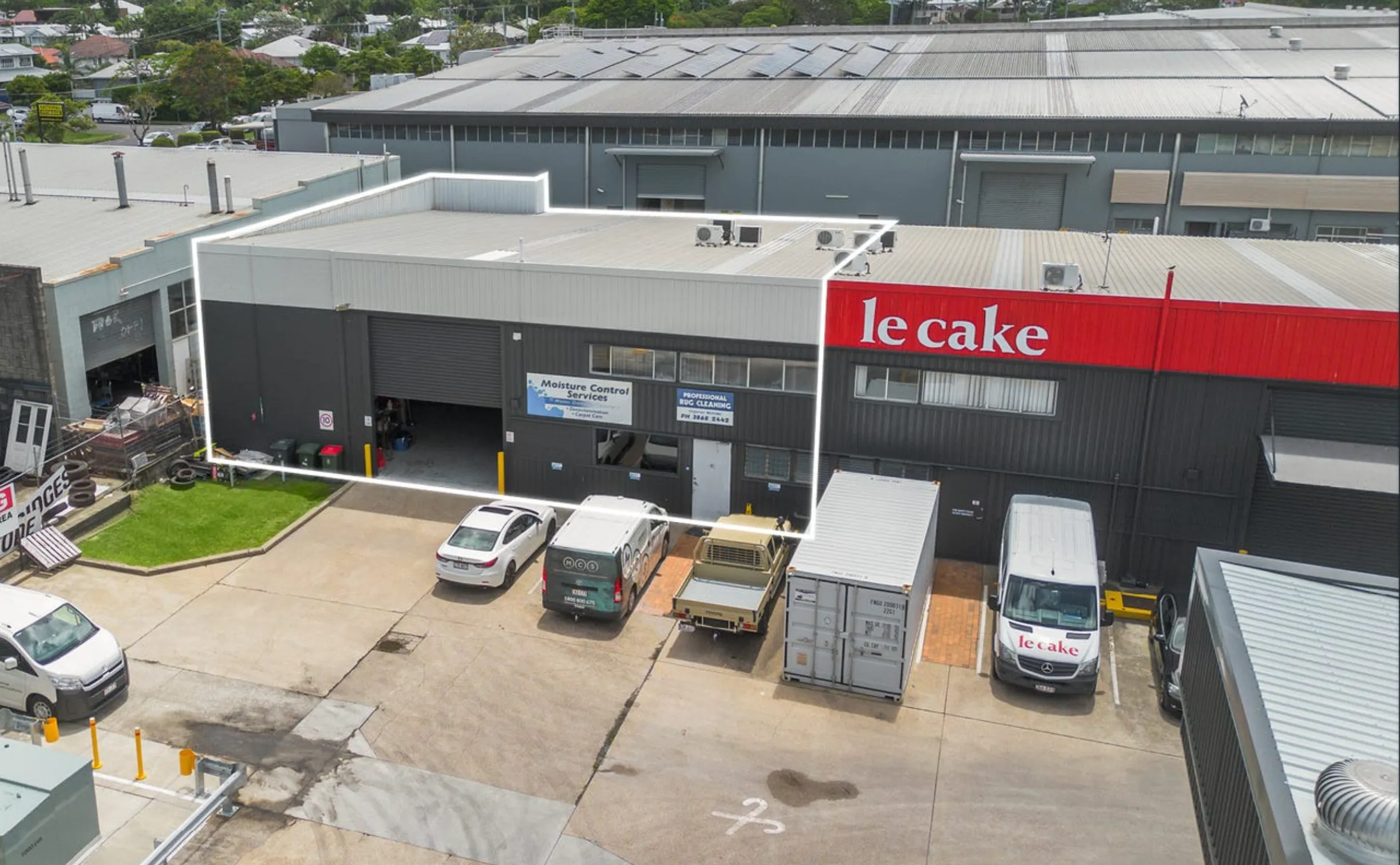 Aerial view of an industrial warehouse complex with Le Cake branding