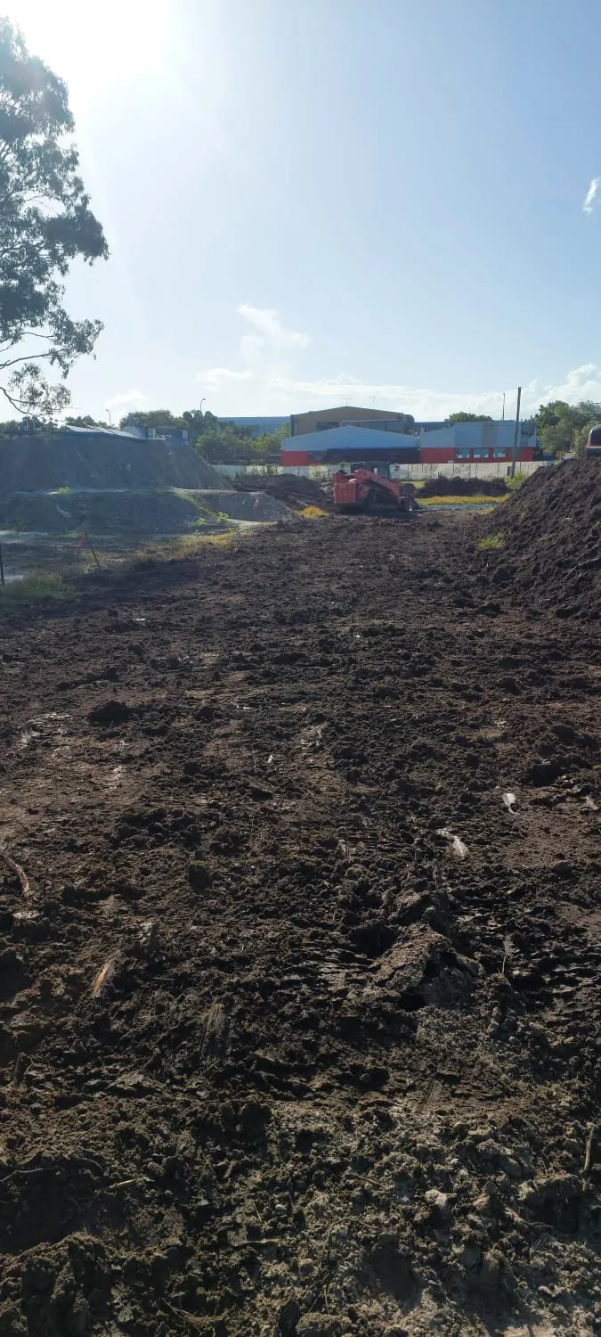 Excavator decontaminating an asbestos-contaminated soil site