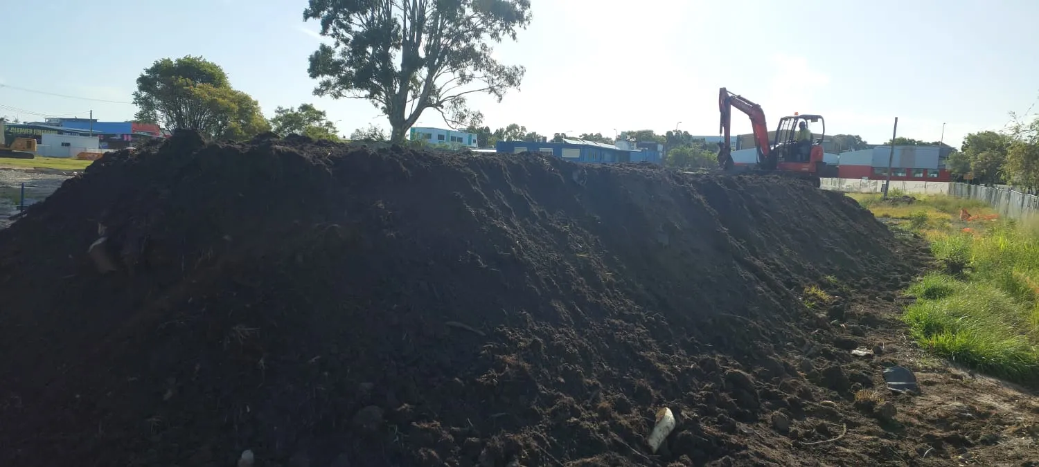 Excavator working an asbestos soil remediation site